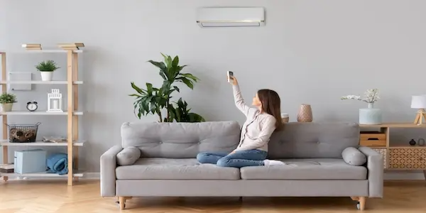 Woman sitting on couch checking termpature