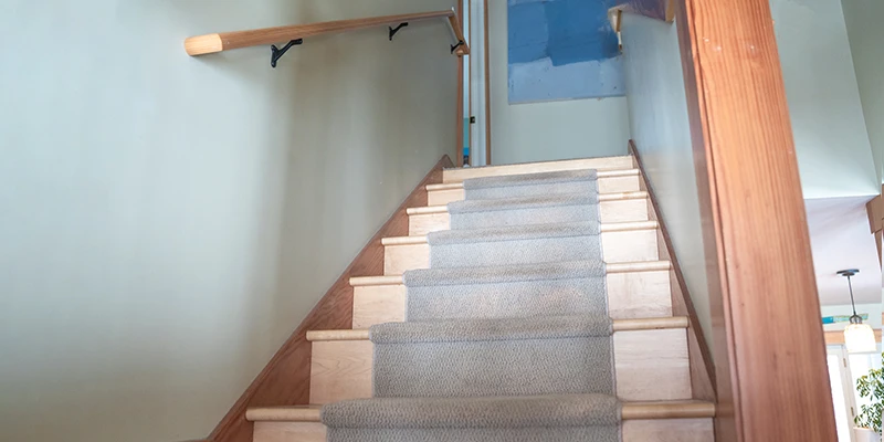 Close-up of stairs leading up to second floor landing of residential home with blue walls.