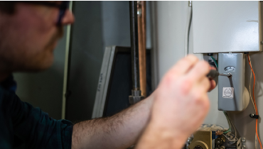 Close-up of man repairing water heater.