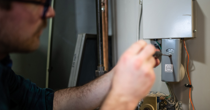 Close-up of man repairing water heater.