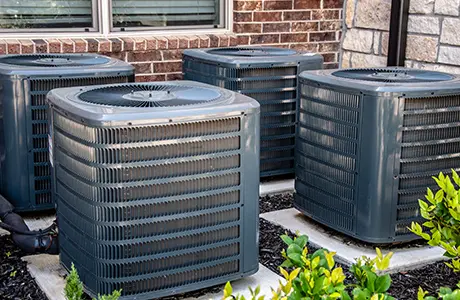 Four large HVAC units on individual concrete pads.